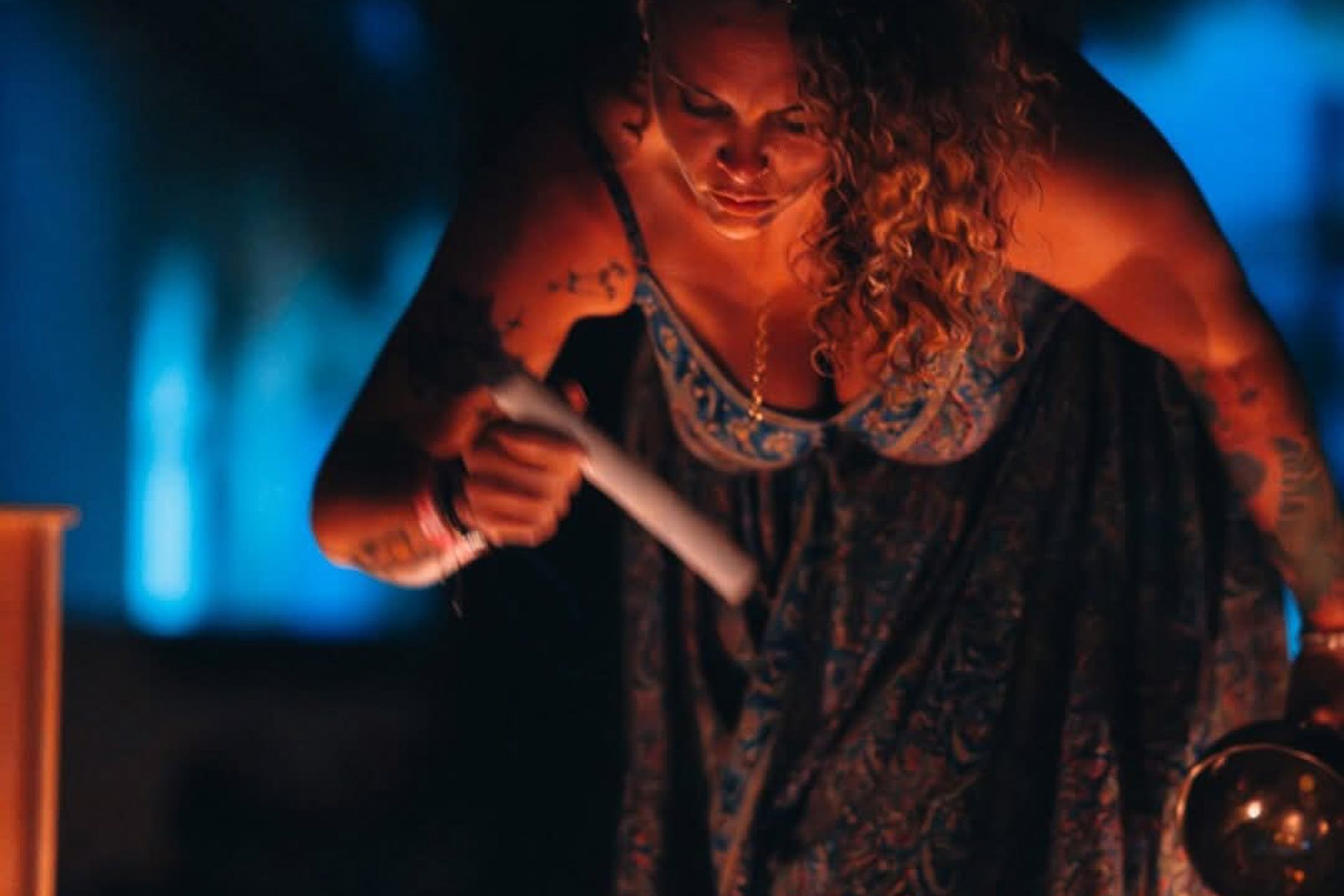 Tasha playing a crystal singing bowl by candlelight