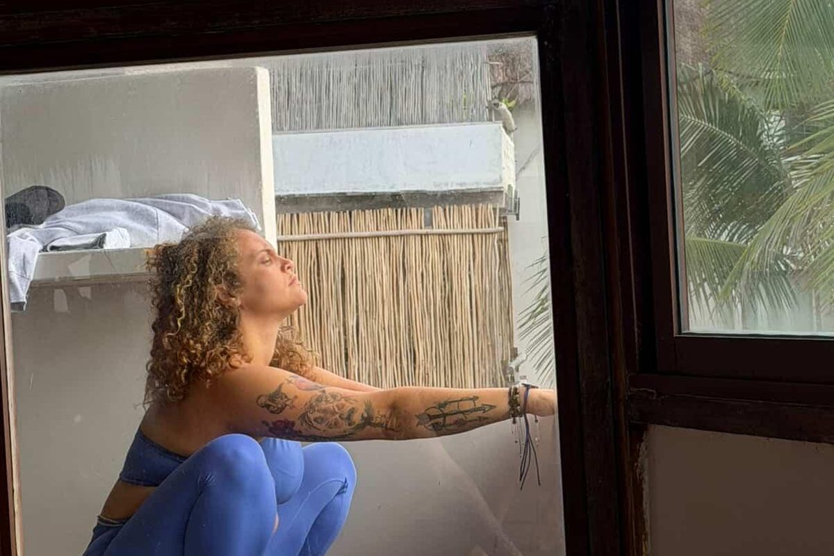 Tasha resting in a supported reclining pose beside an open window