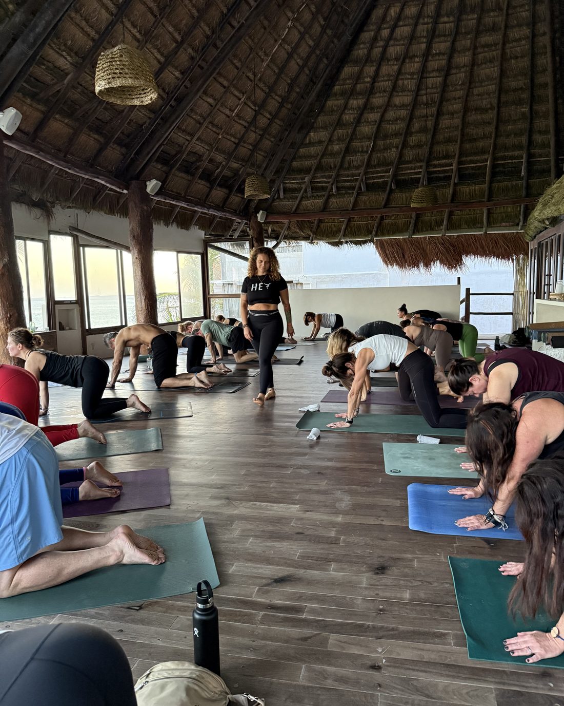 Tasha teaching a morning yoga class in an open-air palapa above the ocean