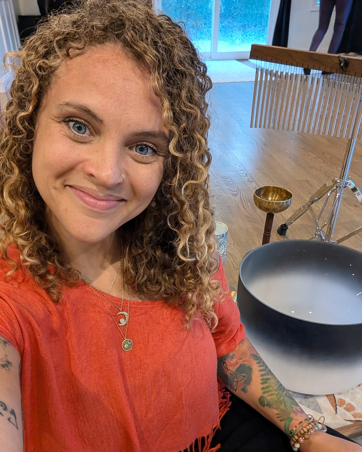 Tasha seated with her crystal sound bowls, smiling warmly